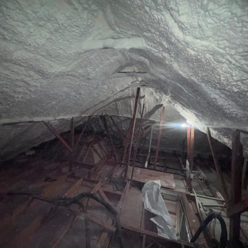 Professional air sealing using spray foam in residential attic.