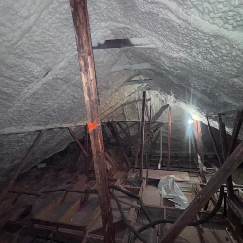 Professional air sealing using spray foam in residential attic.